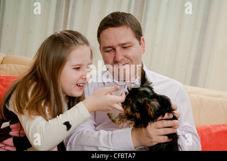 Heureux l'enfant et son père jouent avec chien à la maison Banque D'Images