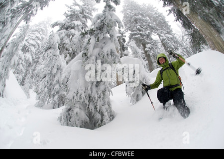 Jeune femme en raquettes sur le sentier du lac d'abord à Seymour Mountain. North Vancouver, Colombie-Britannique, Canada Banque D'Images