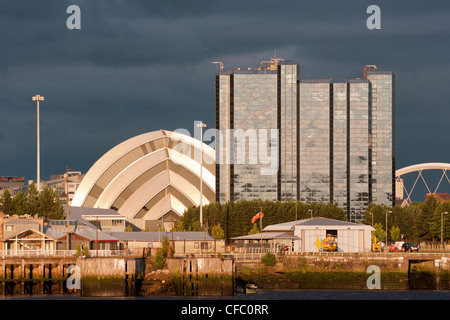 La lumière du soleil sur les bâtiments comme les nuages de tempête rassembler au bord de la rivière Clyde à Glasgow, Écosse, Royaume-Uni, Europe Banque D'Images