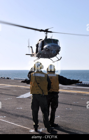 Les copains de l'aviation de Boatswain dirigent l'atterrissage d'un HUEY UH-1N sur le pont de vol du navire d'assaut amphibie USS Kearsarge. Kearsarge est en cours, en train de terminer la formation de base du groupe de formation 1.3. Banque D'Images