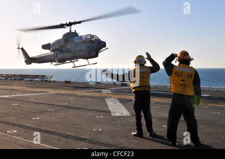 Les copains d'aviation de la compagnie aérienne dirigent l'atterrissage d'un Super Cobra AH-1W sur le pont de vol du navire d'assaut amphibie USS Kearsarge. Kearsarge est en cours, en train de terminer la formation de base du groupe de formation 1.3. Banque D'Images