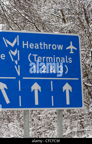 Signe de route pour l'aéroport d'Heathrow sur M4 au cours de la neige lourde de perturbations. Banque D'Images