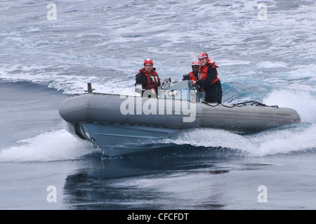 Des marins à bord d'un bateau gonflable à coque rigide à la suite du navire d'assaut amphibie USS Kearsarge (LHD 3) pendant un exercice de l'homme à la mer. Kearsarge est en cours, en train de terminer la formation de base du groupe de formation 1.3. Banque D'Images