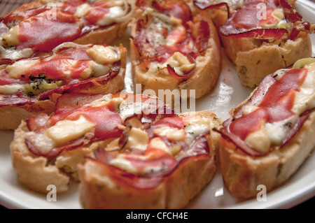 Très savoureux bruschettes sur une plaque blanche sur une table de cuisine. Banque D'Images