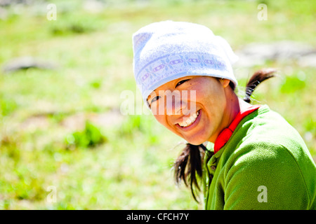 Une femme sourire alors qu'elle siège dans une prairie alpine. Elle est juste à côté de la ligne de Trail (CCT, nombre de sentiers 813) juste au nord Banque D'Images