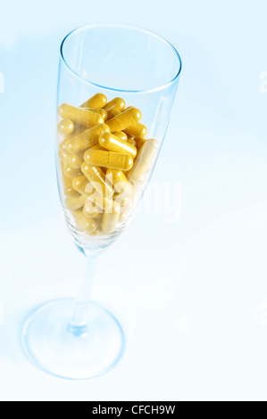 Image conceptuelle sur le risque de prendre des pilules avec de l'alcool. Fond bleu. Banque D'Images