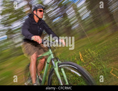 Homme vtt à travers la forêt autour de Whitehorse, au Yukon. Banque D'Images