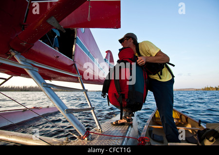 Un homme charge un hydravion à voler à la maison après un voyage en canot de 2 semaines dans le parc Wabakimi Provincial Park, Ontario, Canada Banque D'Images