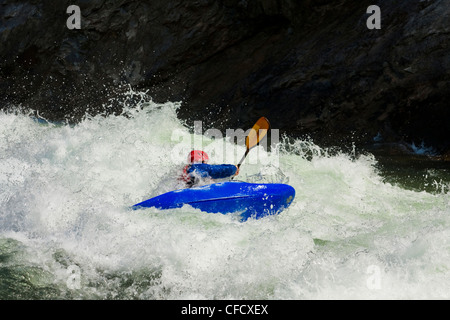 Un kayakiste d'eau vive paddles grâce à une 4 e année sur le rapide de la rivière Clearwater, Colombie-Britannique, Canada Banque D'Images