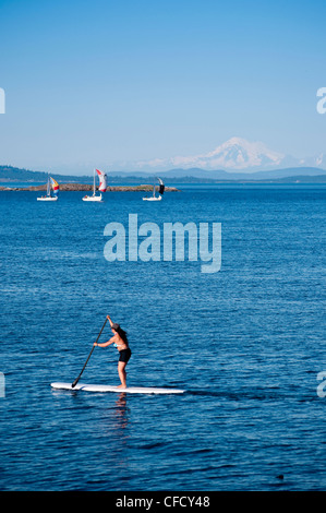 Paddleboarder et voiliers avec spinnakers de Royal Victoria Yacht Club, Victoria, Colombie-Britannique, Canada Banque D'Images