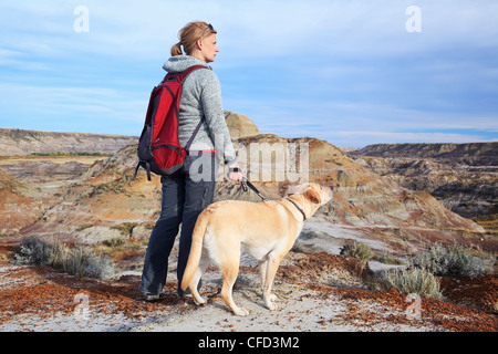 Randonnée femme avec son chien, debout sur un un panorama. Voleur de chevaux Canyon, Drumheller, Alberta, Canada. Banque D'Images