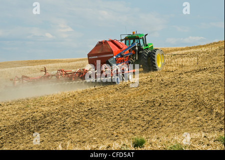 Déplacer le tracteur et l'air jusqu'à la plantation semoir dans un canola jusqu'à zéro les chaumes de blé champ, Bruxelles, Manitoba, Canada Banque D'Images