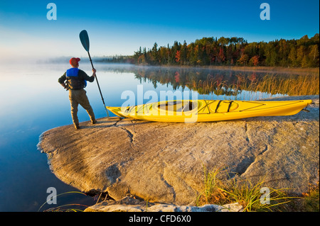 Homme avec kayak,Bunny Lake, près de Sioux Narrows, nord-ouest de l'Ontario, Canada Banque D'Images