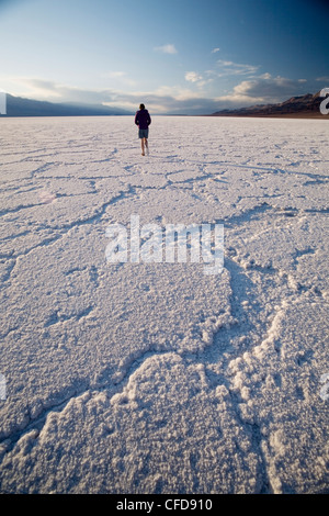 Femme marche sur les plaines salines, Badwater Basin, Death Valley National Park, California, USA Banque D'Images