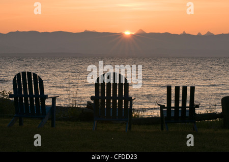 Chaises Adirondack alignés sur la plage au lever du soleil. Merville, British Columbia, Canada Banque D'Images