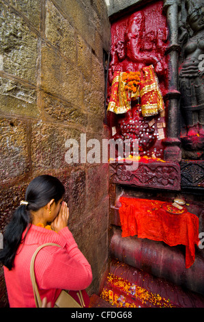 Pèlerin en face d'une statue en pierre de couleur rouge dans le temple hindou Kamakhya, Guwahati, Assam, Inde, Asie Banque D'Images