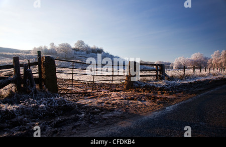 Par la ferme sur la route d'hiver glacial matin Banque D'Images