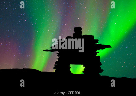 Inukshuk découpé sur la toundra, northern lights, centre des Territoires du Nord-Ouest, de l'Arctique canadien Banque D'Images