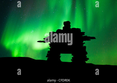 Inukshuk découpé sur la toundra, northern lights, centre des Territoires du Nord-Ouest, de l'Arctique canadien Banque D'Images