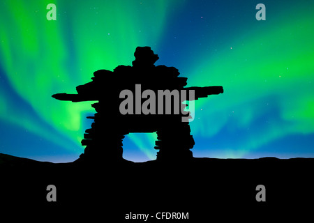 Inukshuk découpé sur la toundra, northern lights, centre des Territoires du Nord-Ouest, de l'Arctique canadien Banque D'Images