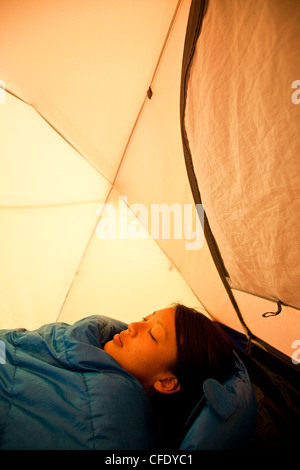 Une jeune femme se réveille en camping dans le parc provincial de Jasper, Alberta, Canada Banque D'Images