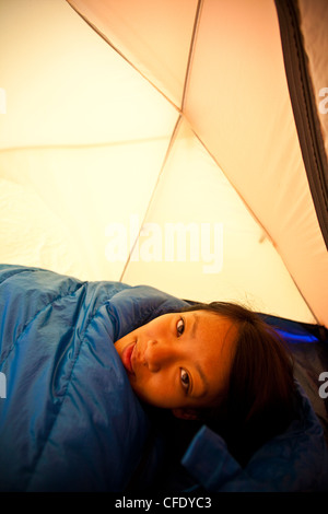 Une jeune femme se réveille en camping dans le parc provincial de Jasper, Alberta, Canada Banque D'Images