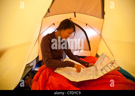 Une jeune femme se réveille et les plans de la journée tout en camping dans le parc provincial de Jasper, Alberta, Canada Banque D'Images