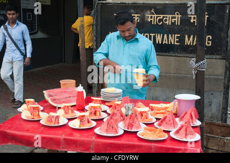 L'homme préparer des collations de fruits frais de plaques à vendre dans le centre-ville de Fort district de Mumbai (Bombay), Inde Banque D'Images