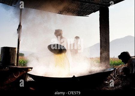 La production de jagré dans le sud rural campagne indienne. Jus de canne à sucre non raffiné de matières premières d'ébullition. L'Andhra Pradesh, Inde Banque D'Images