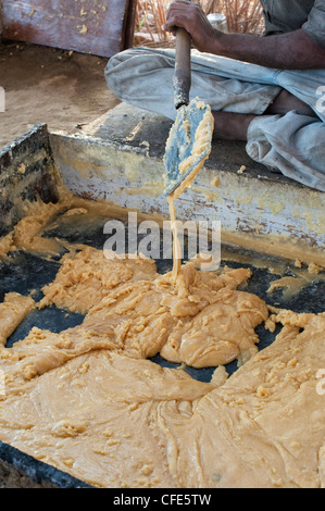 La production de jagré dans le sud rural campagne indienne. Sucre brut brut dans un creux de refroidissement avant de rouler. L'Andhra Pradesh, Inde Banque D'Images