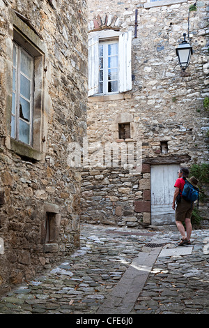Woman backpacker en retour rue de brusque, Aveyron, France Banque D'Images