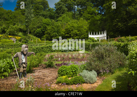 UK, Gloucestershire, Painswick Rococo, maison Jardin, épouvantail dans le jardin cuisine avec coin salon exedra peint en blanc au-delà Banque D'Images