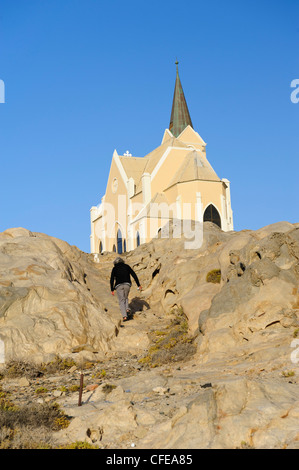 Woman climbing les roches pour l'église Felsenkirche (sur les rochers) à Luderitz, Namibie. Banque D'Images