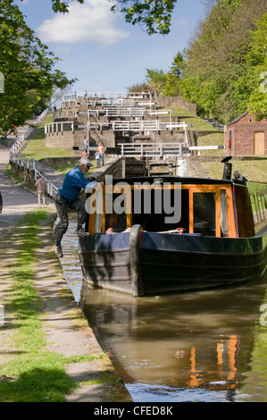 Man jumping à bord 15-04 de halage, après avoir voyagé dans la pittoresque montée cinq écluses - Canal de Liverpool Leeds, West Yorkshire, Angleterre, Royaume-Uni. Banque D'Images