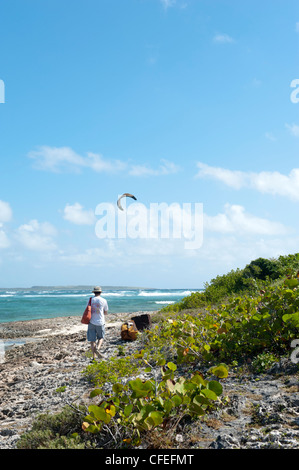 Homme marchant le long de la côte sur la plage d'Orient Bay, Saint Martin Banque D'Images