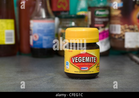 Un pot de l'emblématique petit déjeuner d'un Australien, Vegemite, assis sur le banc en face de la cuisine d'autres sauces et condiments. Banque D'Images