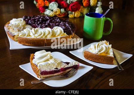 Pâtisserie néerlandaise différents ou flans limbourgeois avec tasses, mugs et fleurs prêt pour un parti - horizontal Banque D'Images