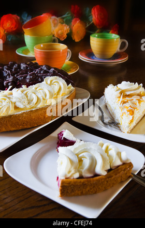 Pâtisserie néerlandaise différents ou flans limbourgeois avec tasses, mugs et fleurs prêt pour un parti - verticale Banque D'Images