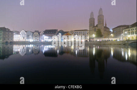 Vue sur le centre de la vieille ville de Zurich et se reflétant dans la rivière Limmat la nuit. Banque D'Images