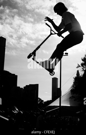 La photo d'un jeune garçon faisant un saut sur un scooter dans un skate parc aux moomba festival 2012 à Melbourne Banque D'Images