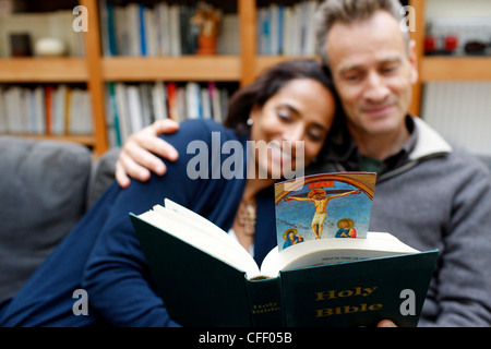 Couple de la lecture de la Bible à la maison, Paris, France, Europe Banque D'Images