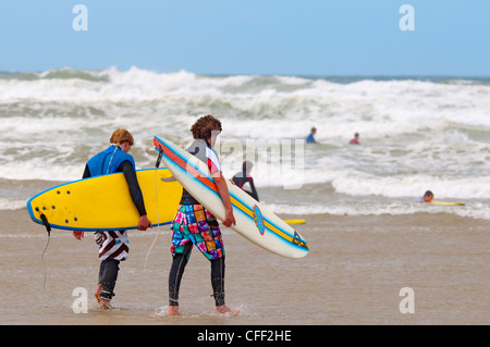 Les surfeurs, la plage de Polzeath, Cornwall, Angleterre, Royaume-Uni, Europe Banque D'Images