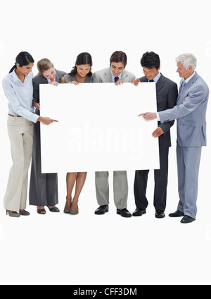 L'équipe d'entreprises multiculturelles holding et montrant une affiche Banque D'Images