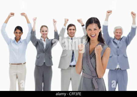 Close-up of a smiling woman serrant ses poings avec une équipe entreprise levant les bras Banque D'Images