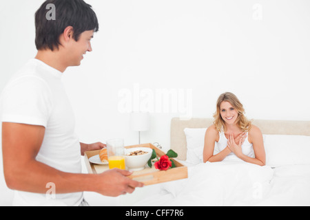 Montre Femme gratitude et sourit en l'homme apporte son petit déjeuner au lit Banque D'Images