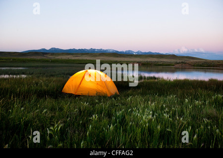 Une tente à côté d'un lac au coucher du soleil, dans le Montana. Banque D'Images