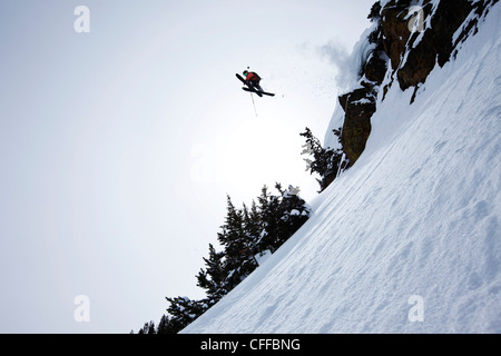 Un skieur de télémark de sauter d'une falaise dans l'arrière-pays dans le Montana. Banque D'Images