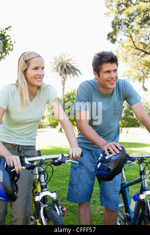 Un couple debout à côté de leur vélo smiling Banque D'Images