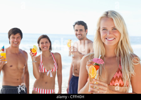 Deux couples sur la plage en prenant des cocktails Banque D'Images