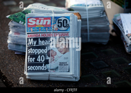 Premiers exemplaires du nouveau journal Le Soleil le dimanche sont vus le long du côté d'autres journal du dimanche dans le nord de Londres le 26 février 2012, Banque D'Images